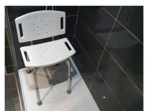 Supportive shower chair in a walk-in shower with a non-slip mat, helping make washing safer and more manageable.