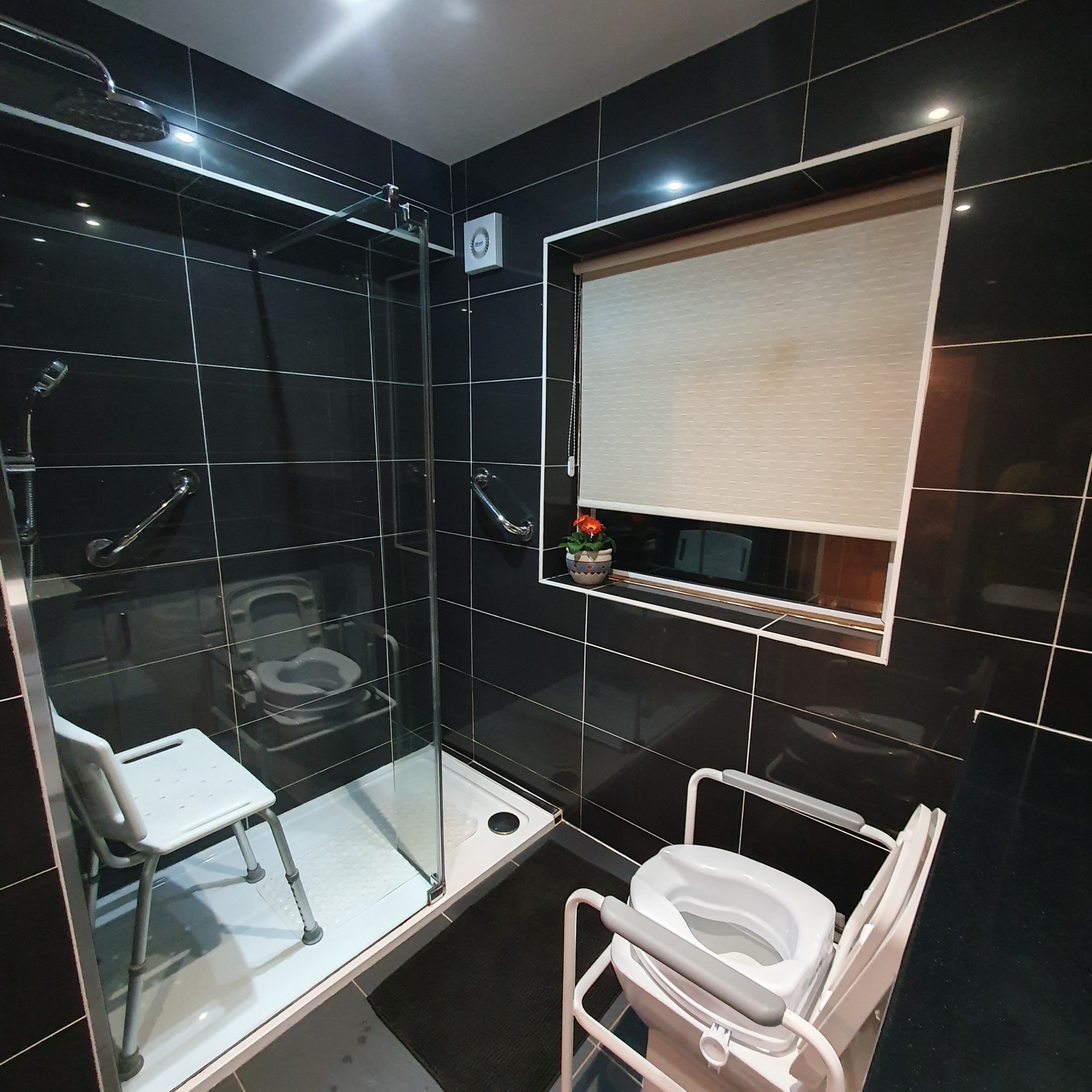 Shower area with grab handles, non slip mat and shower chair for safer support