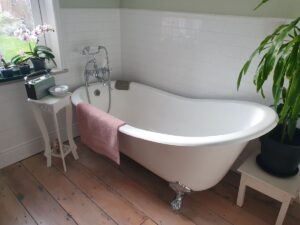 bathroom with freestanding bath,  wooden floor and surrounding items, highlighting features that may affect safety and ease of use
