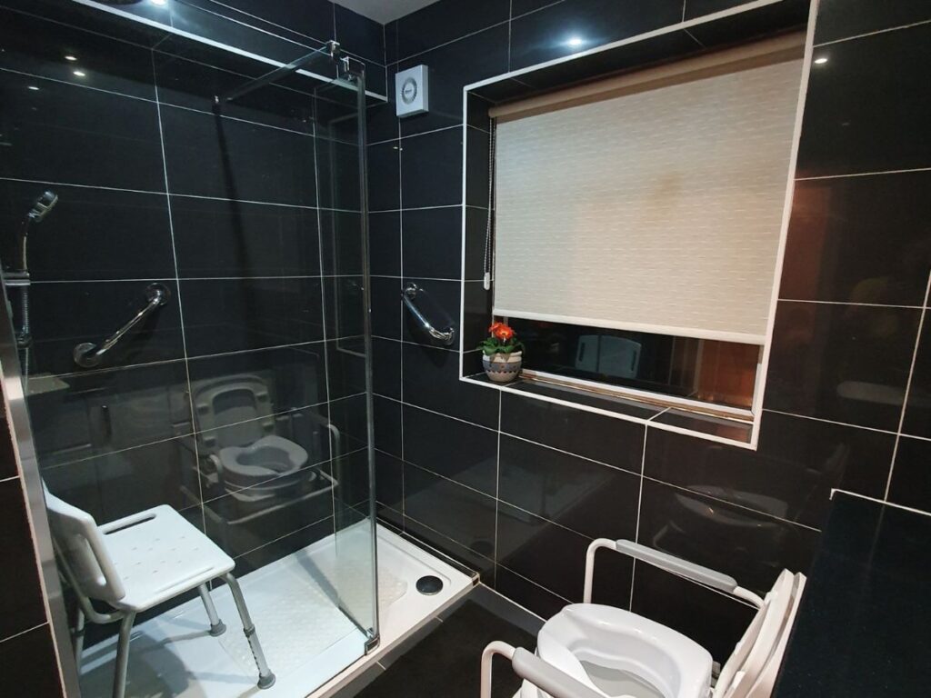 walk in shower with non slip mat and rug, grab rails and shower chair for safer bathing